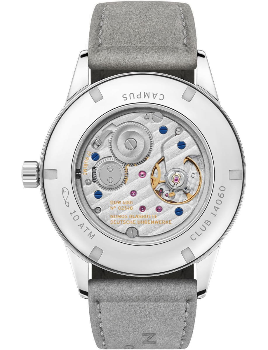 Back of a Nomos wristwatch with an exposed mechanical movement, grey strap, and engraved case back showing gears and blue screws.