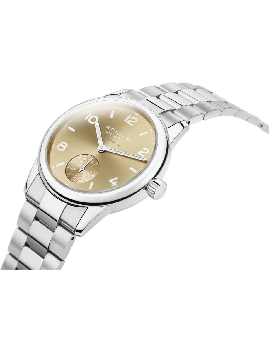 Side view of NOMOS Glashütte wristwatch with stainless steel case and bracelet, and gold dial.