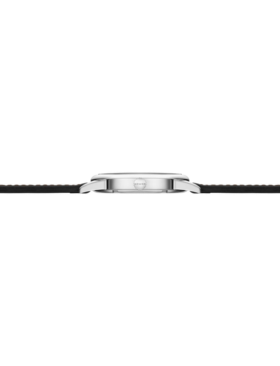 Side view of a Nomos Club wristwatch with stainless steel case, Horween Genuine Shell Cordovan black strap with brown stitching.