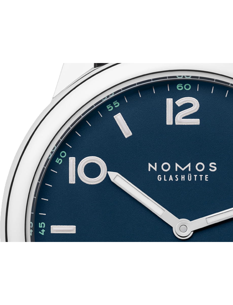 Close-up of a Nomos Club wristwatch with stainless steel case, and atlantic blue dial.