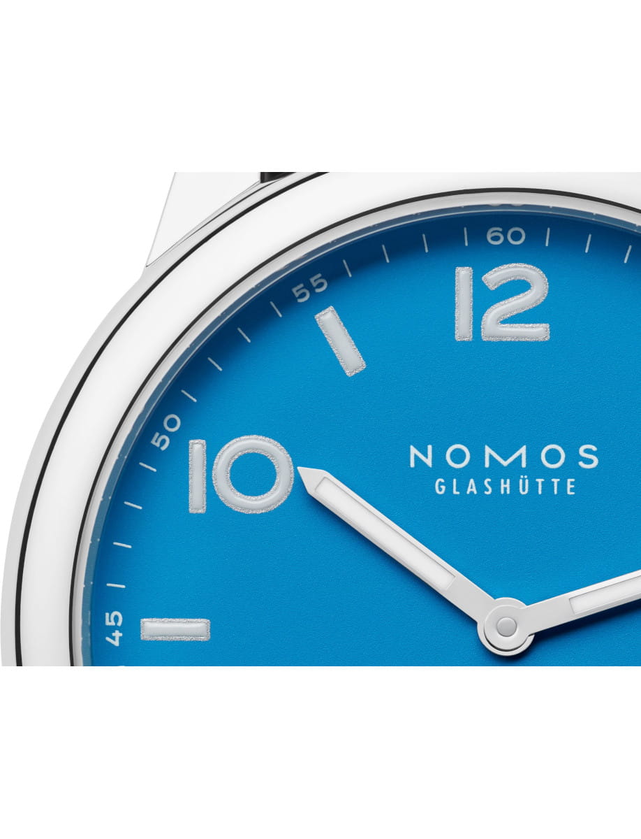 Close up view of Nomos Club wristwatch with stainless steel case and siren blue dial.
