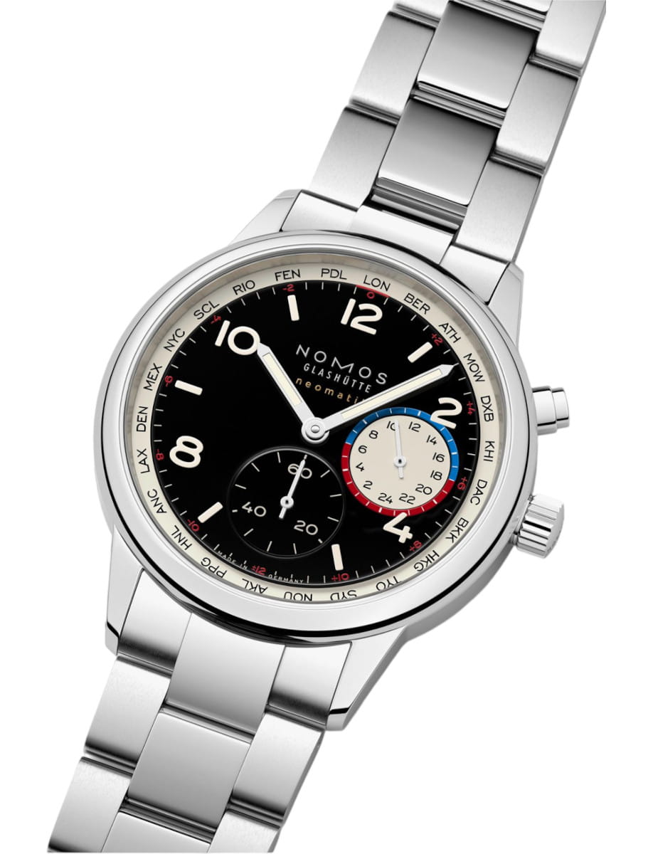 Stainless steel Nomos wristwatch with black dial, multiple subdials, and a world-time bezel; polished bracelet visible in a tilted angle