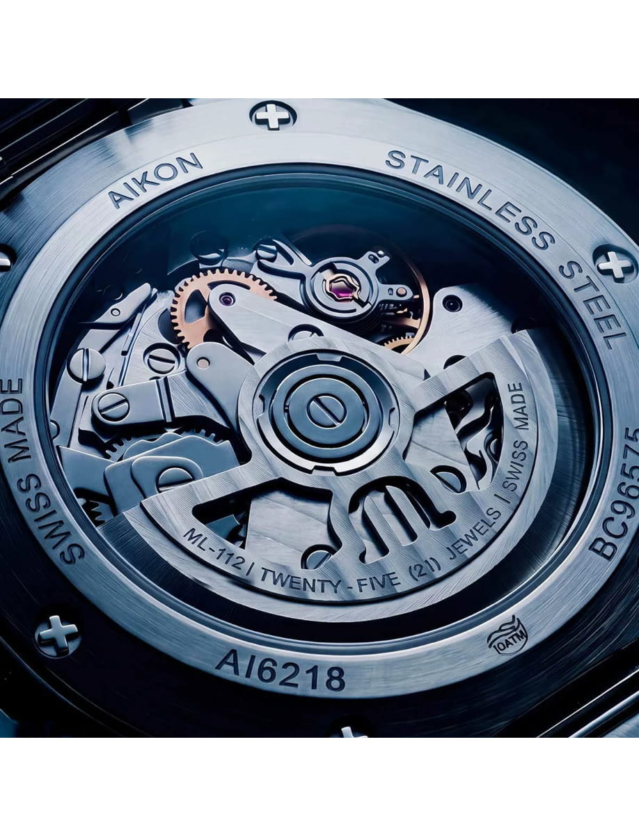 Close-up of a stainless steel watch movement with gears and screws visible through the back case.