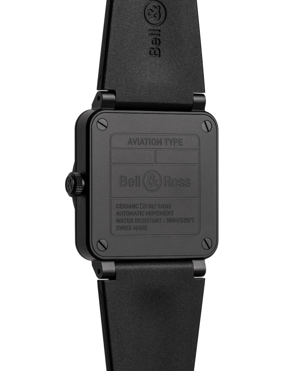 Back of a black Bell & Ross aviation watch with a square case, large screws, and a rubber strap; engraving on the case back reads 'Aviation Type' and 'Bell & Ross'
