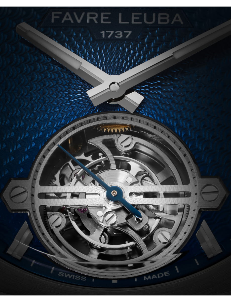 Close-up of a skeleton watch showing exposed gears and blue hands against a textured blue background with Favre Leuba branding.