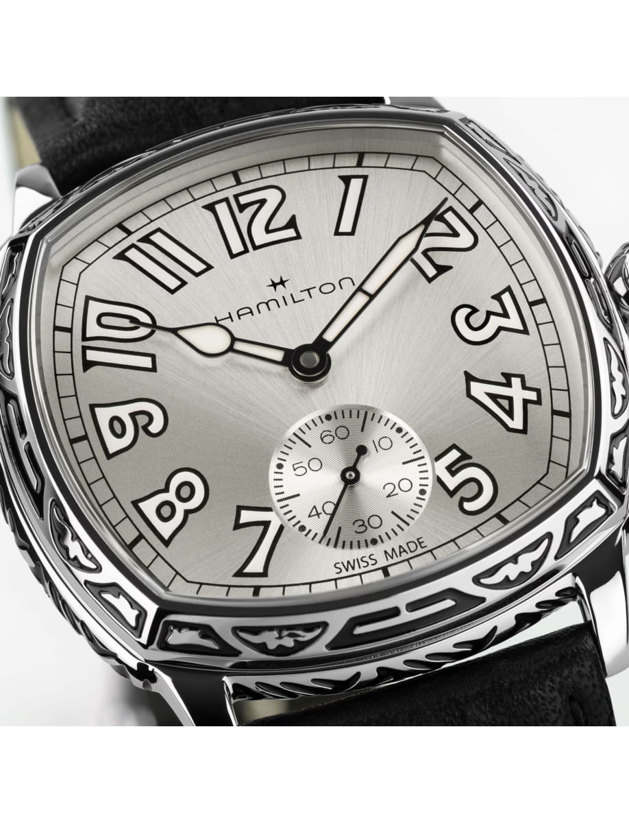 Close-up of a silver Hamilton wristwatch with bold Arabic numerals and a small seconds subdial, Swiss made.