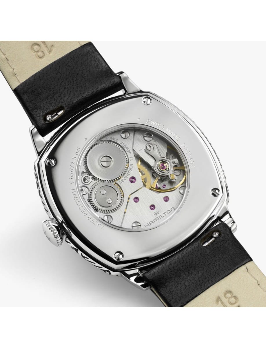 Back of a stainless steel Hamilton watch with a black leather strap and visible mechanical movement through the caseback.