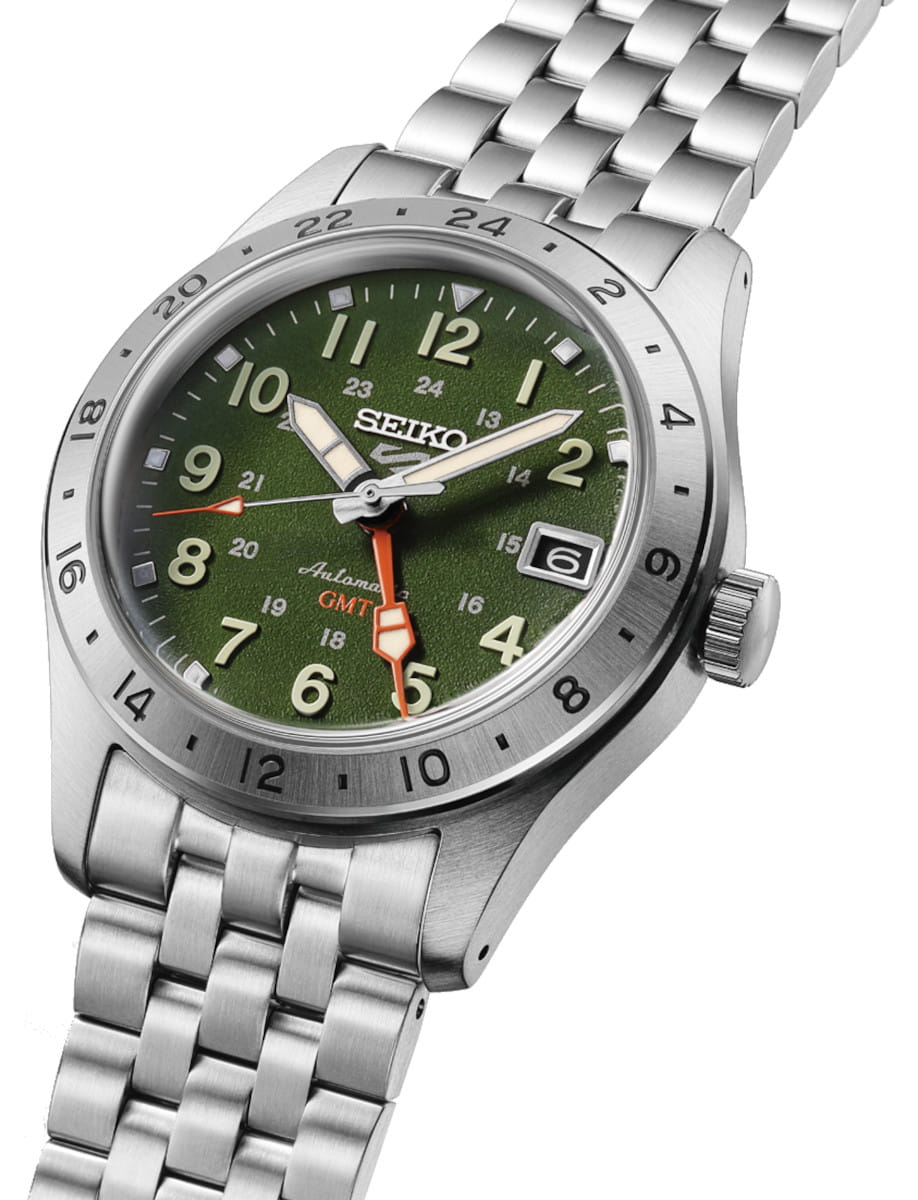 Side view of Seiko wristwatch with stainless steel case and bracelet, and green dial.
