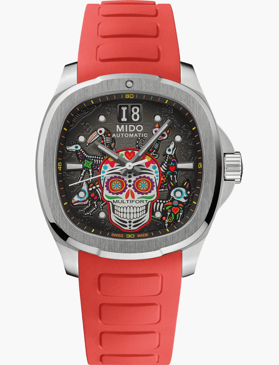 Stainless steel watch with a red rubber strap and a black dial featuring a colorful sugar skull design and 'MIDO Automatic' text at the top center.