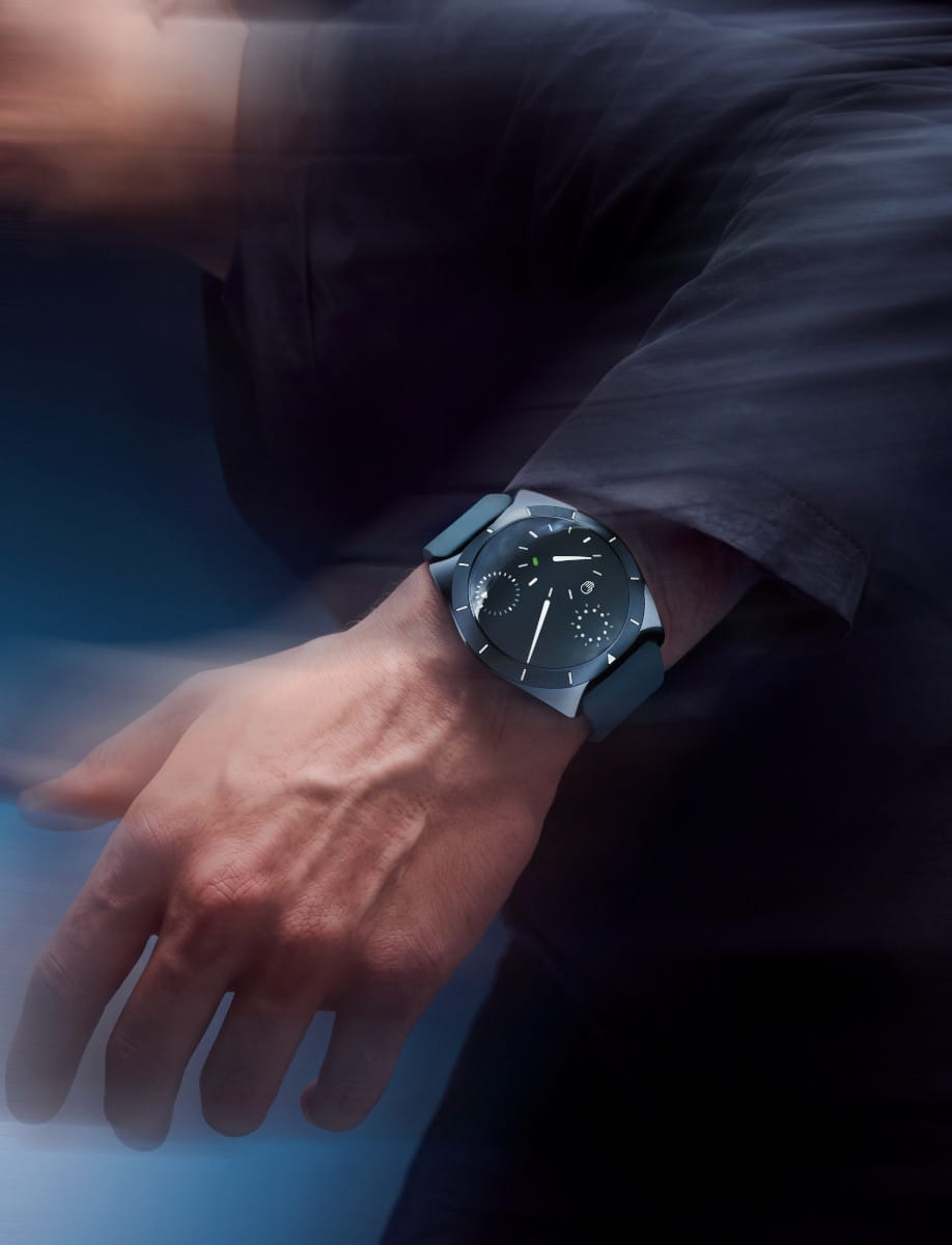 Wristwatch on a left wrist with with grade 5 titanium case and dial, and rubber strap.
