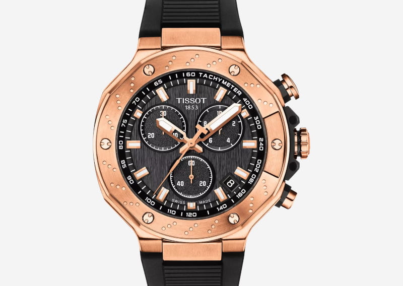 Rose-gold Tissot chronograph watch with a black textured dial, three subdials, and a black rubber strap.